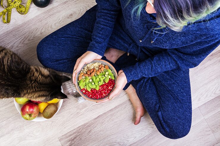 Tutor servindo comida natural para um pet.